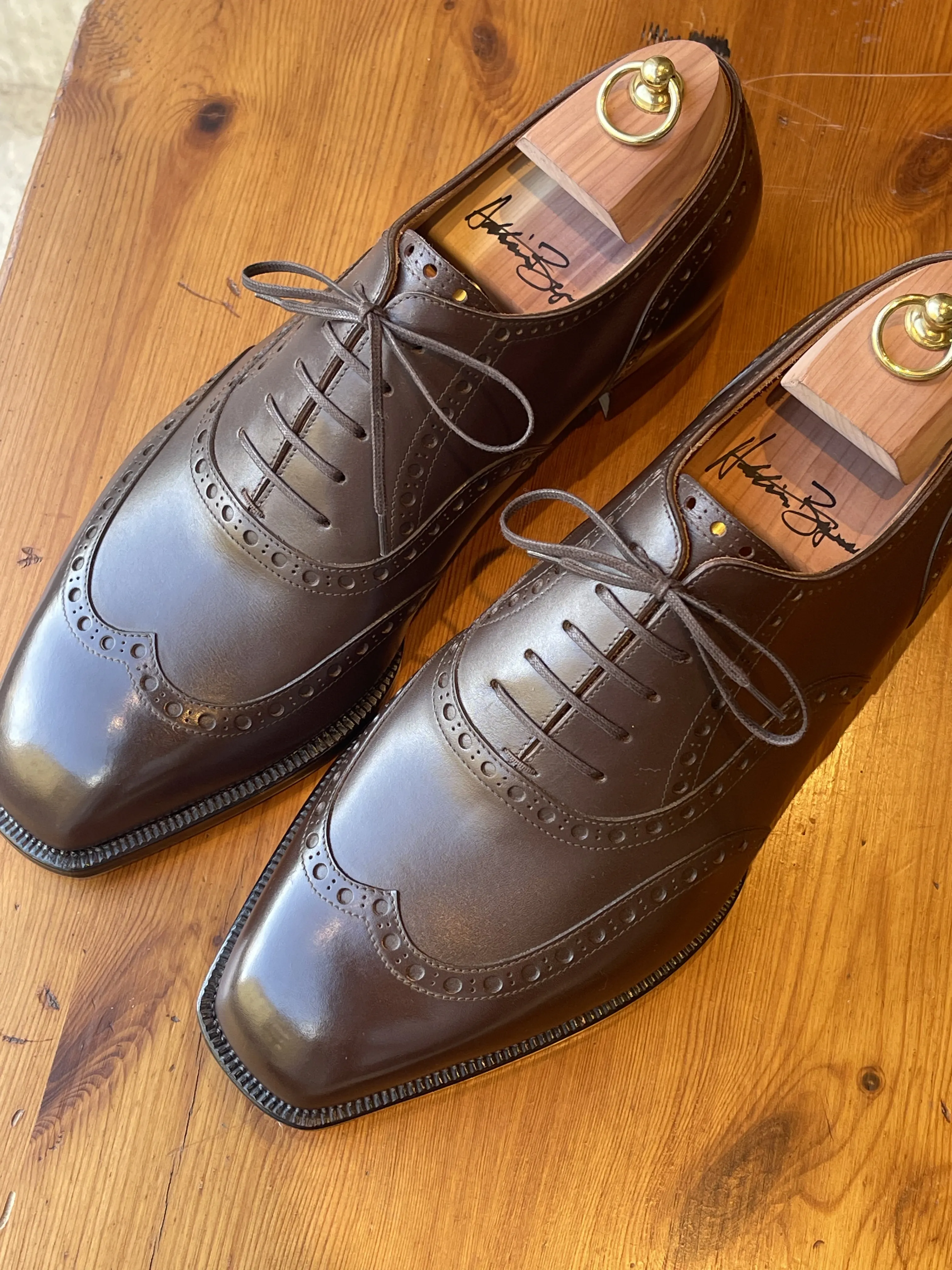Handmade leather shoes on a wooden stool